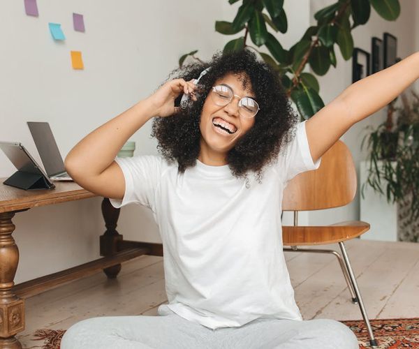 A serene person smiling with eyes closed, embodying a sense of peace and well-being.